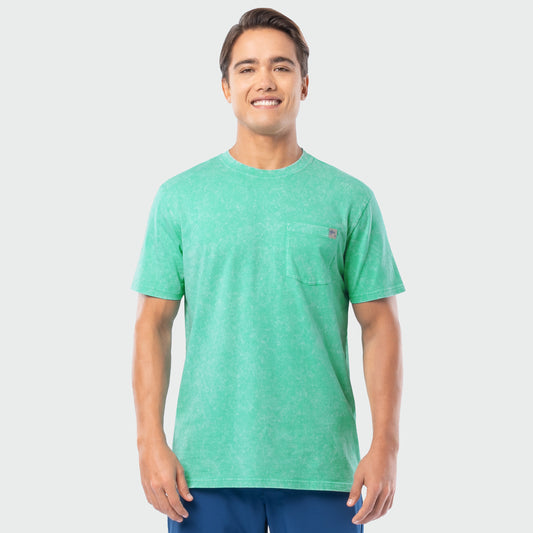 Man wearing a green washed t-shirt with a small logo on a light gray background