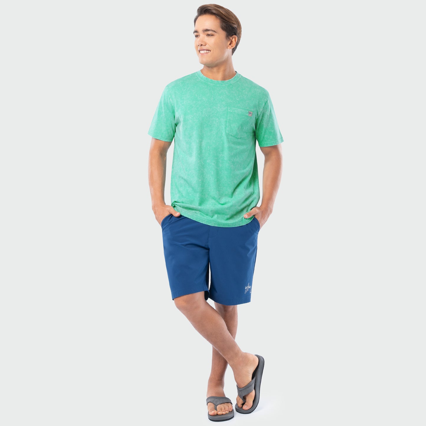 Person wearing a green t-shirt and blue shorts on a white background
