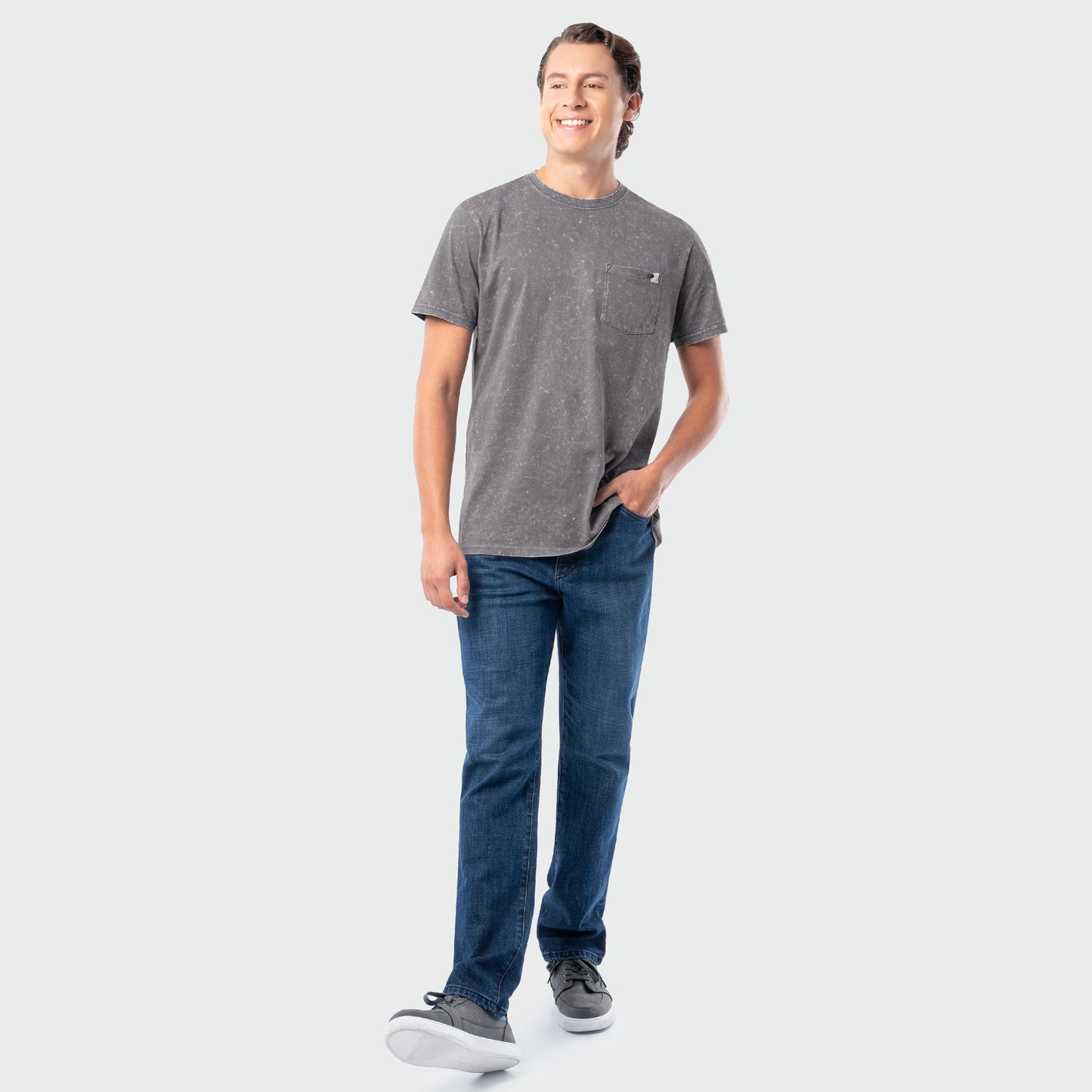 Man wearing a gray t-shirt and blue jeans on a white background