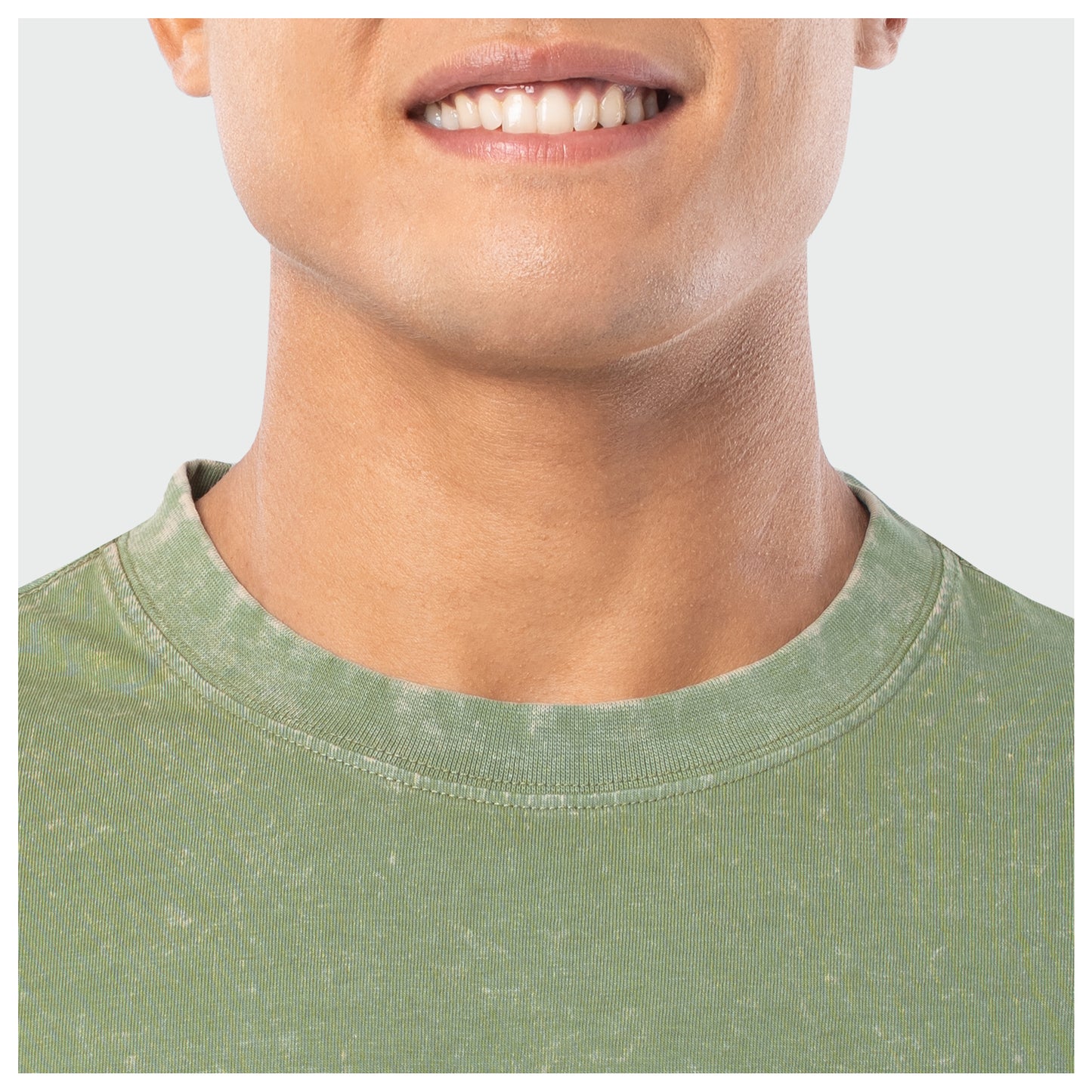 Close-up of a person wearing a green shirt with a plain background
