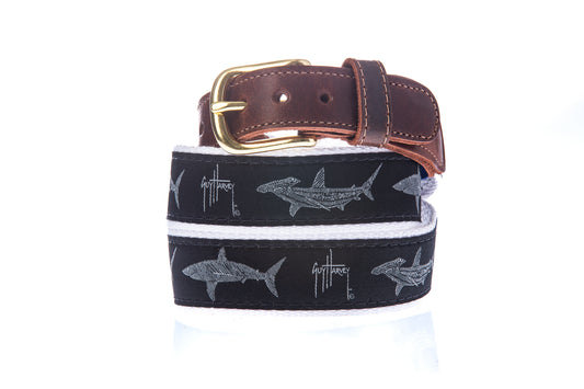 Guy Harvey Men’s Hammerhead and Mako Leather Tab Belt with black cotton webbing, white shark illustrations, brown leather tabs, and brass buckle