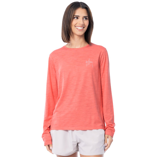 Woman wearing a coral long-sleeve shirt with a small Guy Harvey logo on a white background
