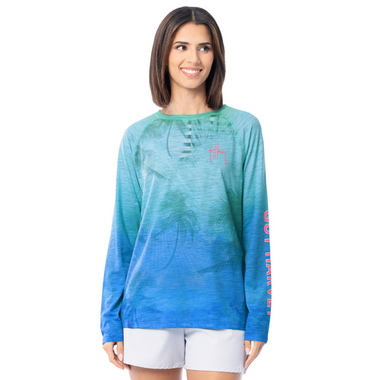Woman wearing a blue and green gradient long-sleeve shirt with a red Guy Harvey logo on a white background