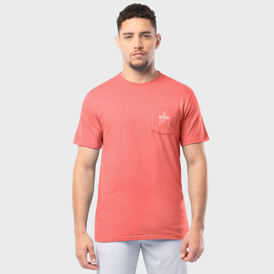 Man wearing a coral t-shirt with a small Guy Harvey logo on a light gray background