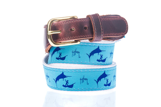 Guy Harvey Old Man and the Marlin Leather Tab Belt with blue cotton webbing, marlin and fisherman silhouettes, and brown leather tabs