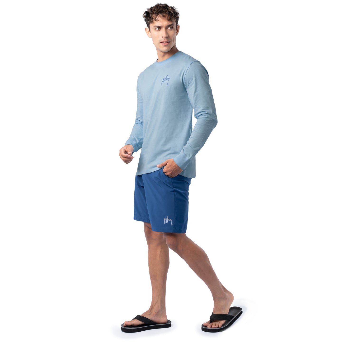 Lifestyle photo of model wearing Guy Harvey Men’s Blue Hawaiian Lightweight Long Sleeve Tee near the coast