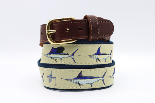 Guy Harvey Men’s Grand Slam Leather Tab Belt with tan cotton webbing, marlin, sailfish, and swordfish art, brown leather tabs, and brass buckle