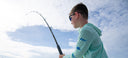 A kid wearing a Marlin Air Hood sun protection from Guy Harvey while fishing