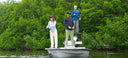 A man and women inshore fishing wearing Guy Harvey Marlin air sun protection tops and Angler Edge Fishing Pants