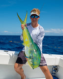 Man holding a large fish on a boat with a clear blue sky and ocean background