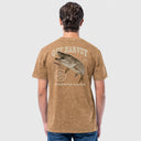 A man viewed from the back wearing a brown mineral-wash graphic t-shirt with a large fish design and the text 'GUY HARVEY' and 'FRESHWATER FIGHTER'.