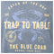 A square graphic print featuring a blue crab illustration with distressed cream text reading 'Catch of the Day,' 'Trap to Table,' 'The Blue Crab,' and 'Annual Crab Boil,' plus 'Est. 1986' and a circular 'Guy Harvey's Provisions' emblem.