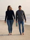 Two people walking on a beach wearing a quarter zip from Guy Harvey.