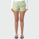 A model wearing light green and beige camouflage shorts, a white long-sleeve shirt, and black flip-flops, shown from the waist down against a light gray background.