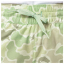 Close-up of a pair of Mallard Camo shorts in light green and off-white, featuring an elastic waistband and a matching green drawstring tied in a bow.