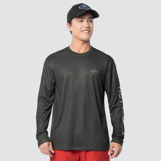 Man wearing a black long-sleeve sun protection shirt with a logo on a gray background