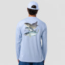 A man viewed from behind wearing a light blue long-sleeve performance shirt with a large graphic print of three fish on the back, paired with a white baseball cap and blue shorts, against a light gray studio background.