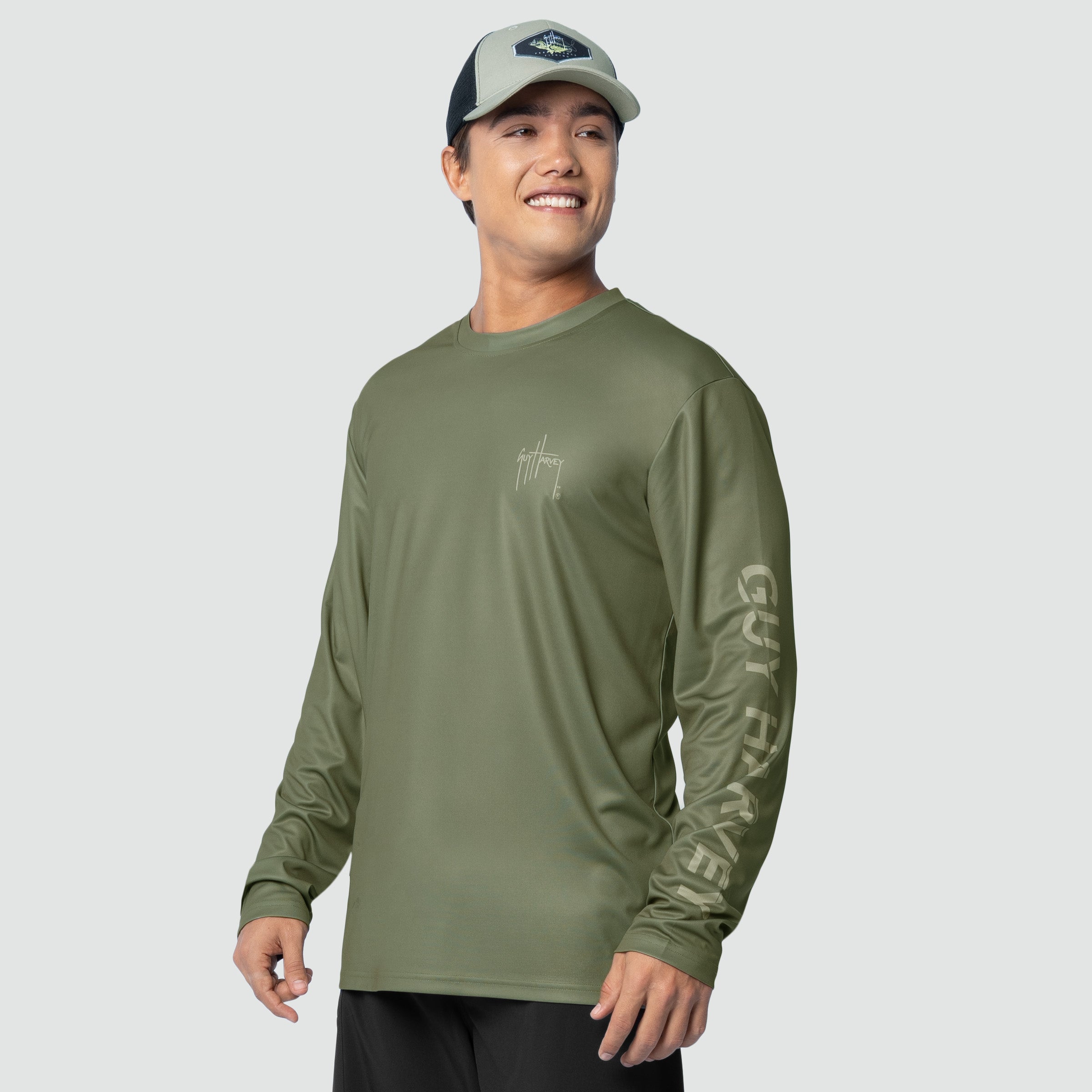 Man wearing a green long-sleeve shirt with text on sleeves against a white background