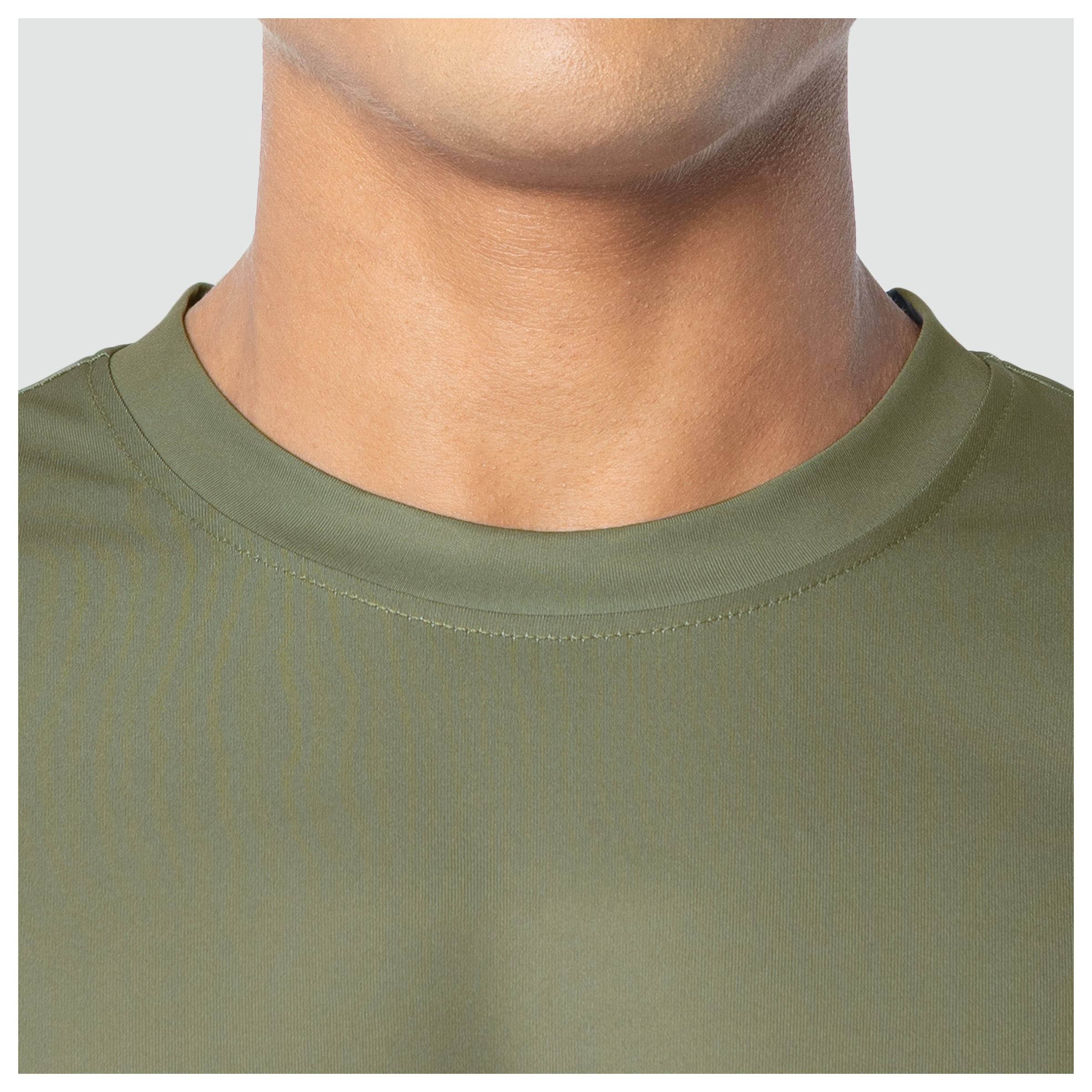 Close-up of a person wearing an olive green shirt with a plain background