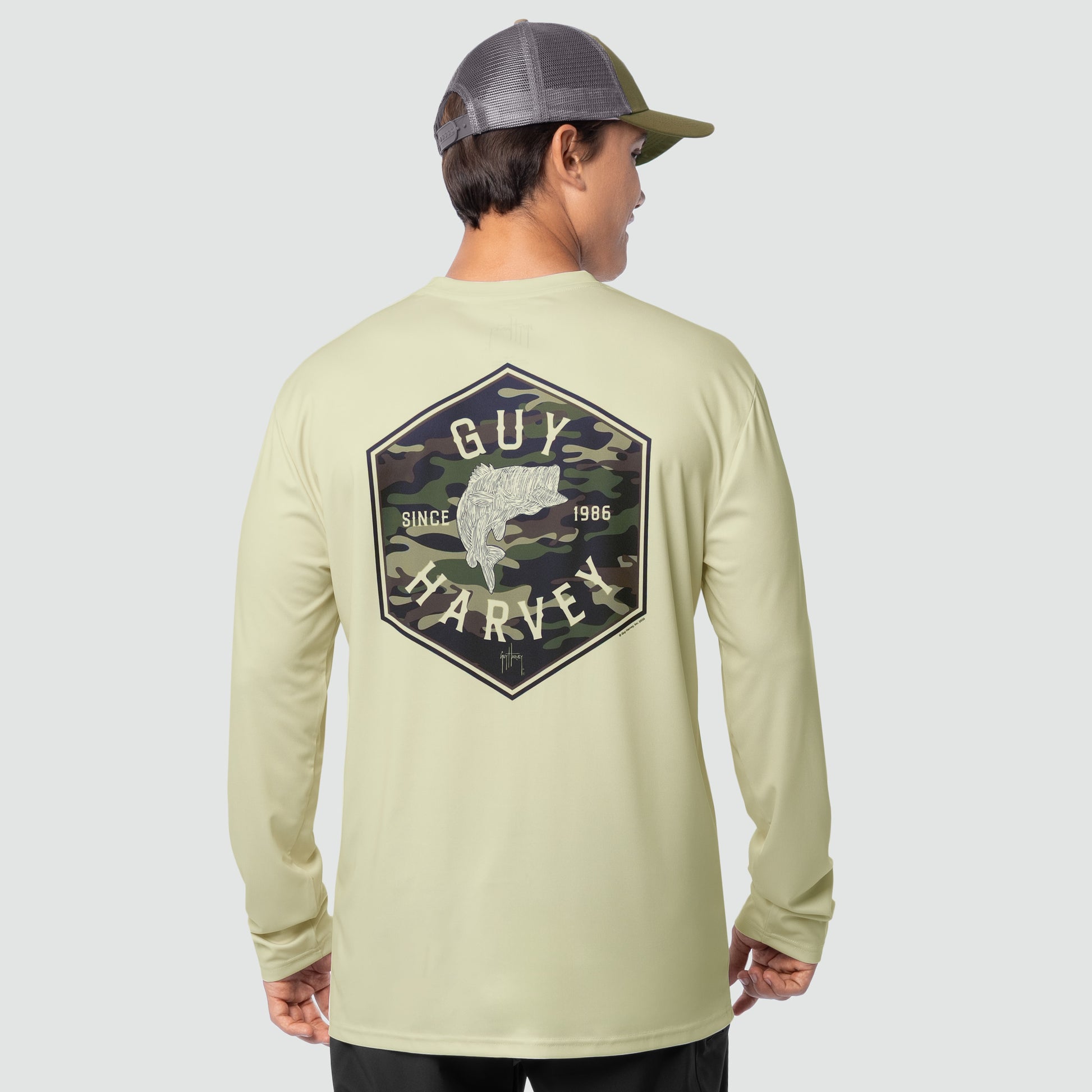 Person wearing a Guy Harvey long-sleeve shirt with a logo on the back against a gray background