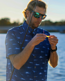 Man baiting a hook wearing short sleeved button down