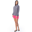 Woman wearing a gray hoodie and pink shorts on a white background
