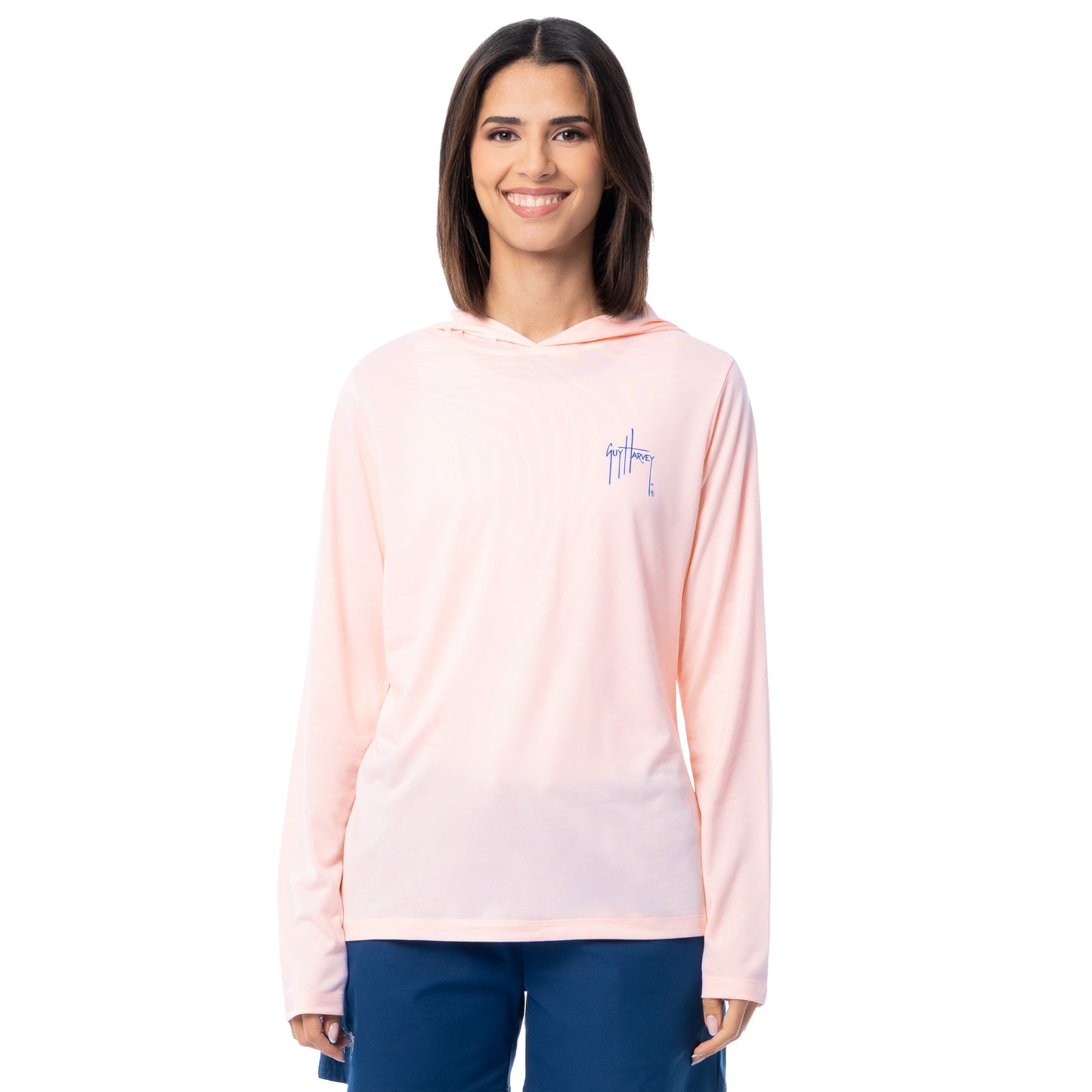 Woman wearing a light pink long-sleeve shirt with a small Guy Harvey logo on a white background