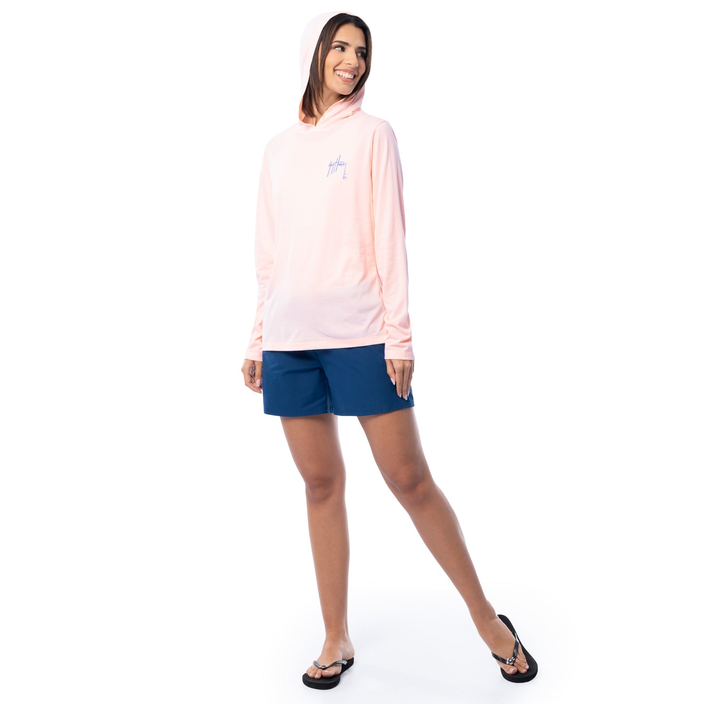 Woman wearing a light pink hoodie and blue shorts on a white background