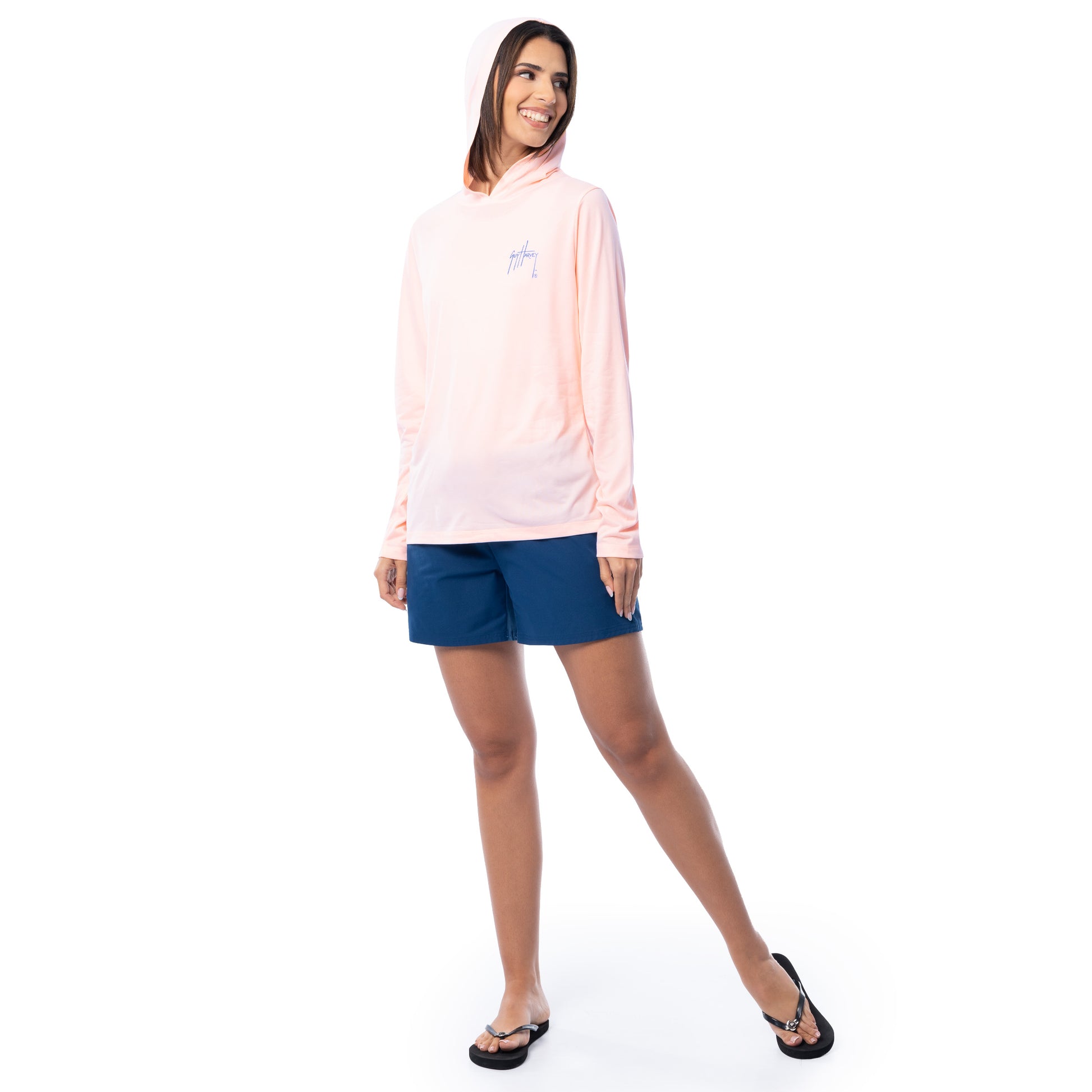 Woman wearing a light pink hoodie and blue shorts on a white background