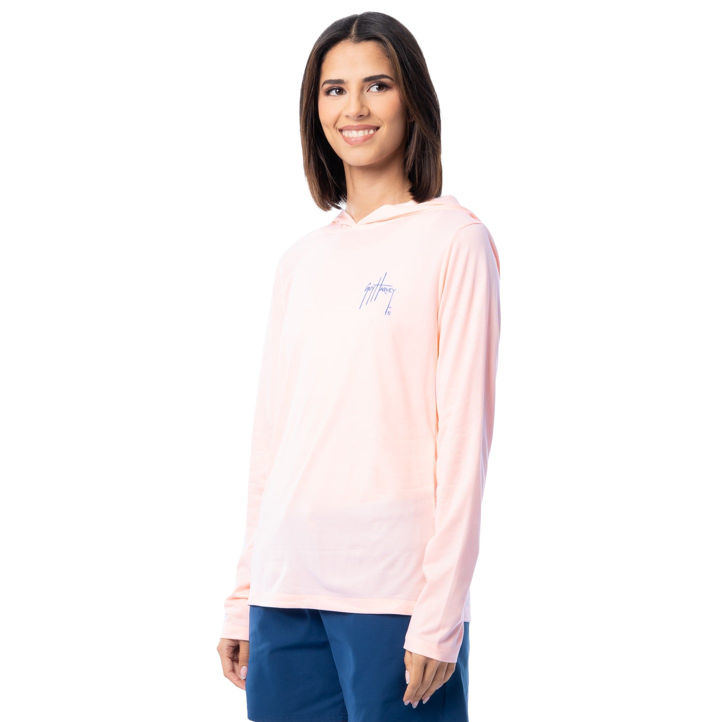 Woman wearing a light pink long-sleeve shirt with a logo on a white background
