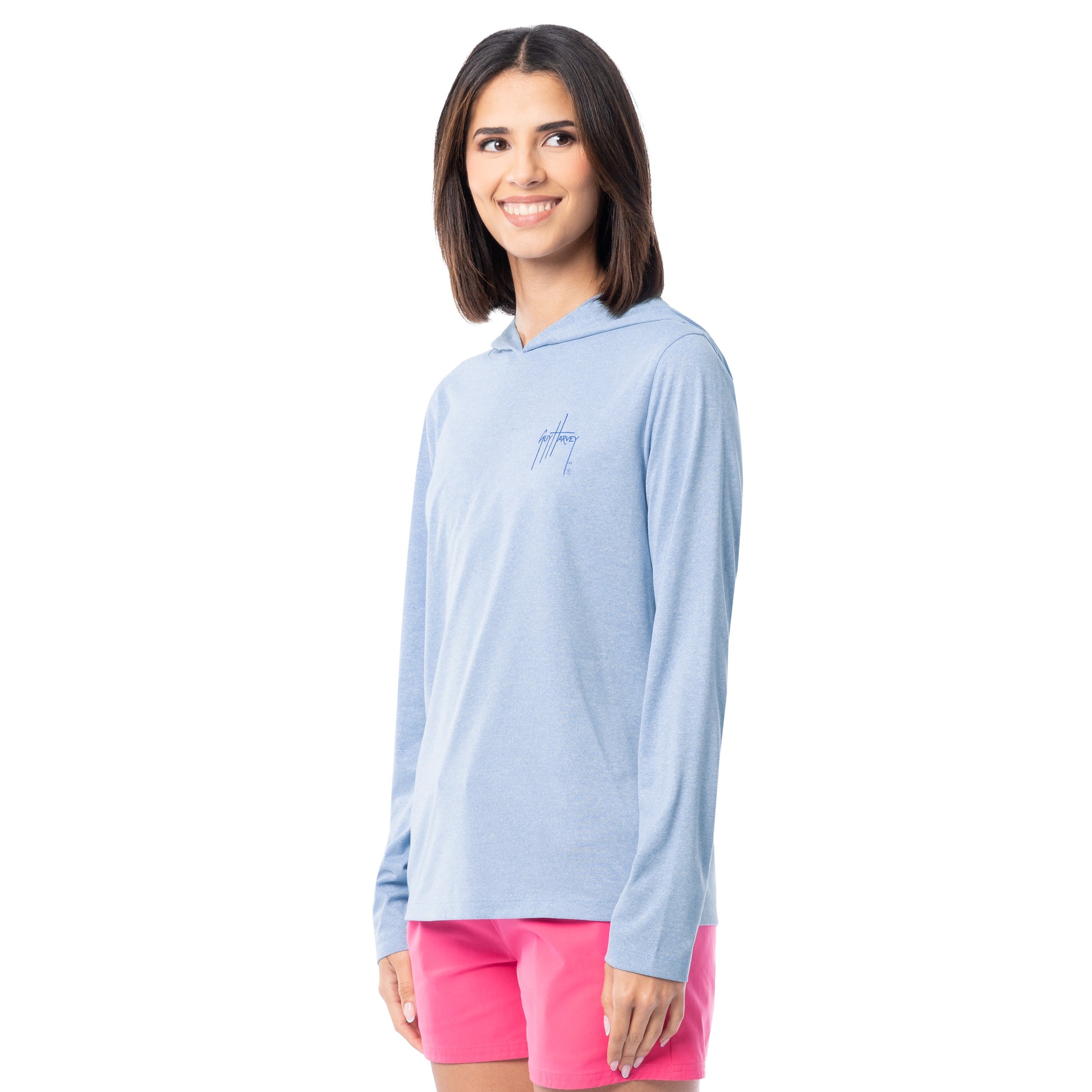 Woman wearing a light blue long-sleeve shirt with a logo on a white background