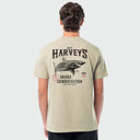 A man viewed from behind wearing a light beige heather t-shirt with a large graphic print on the back featuring a shark, the text 'GUY HARVEY'S SHARK CONSERVATION'.