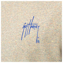 A close-up of a heather gray knit fabric with a blue handwritten signature reading 'Guy Harvey' in the center.