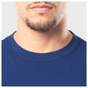 Close-up of a person wearing a blue shirt with a neutral background