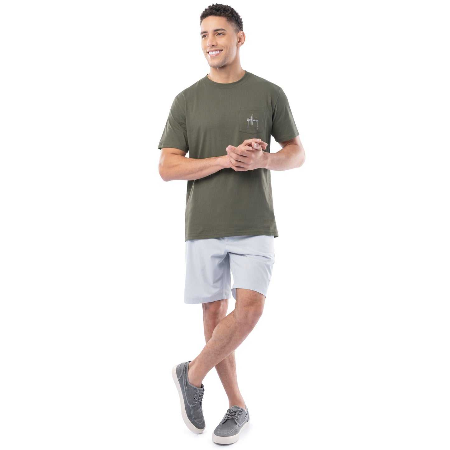 Man wearing a green t-shirt and light gray shorts on a white background
