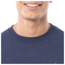 Close-up of a person wearing a blue shirt with a plain background