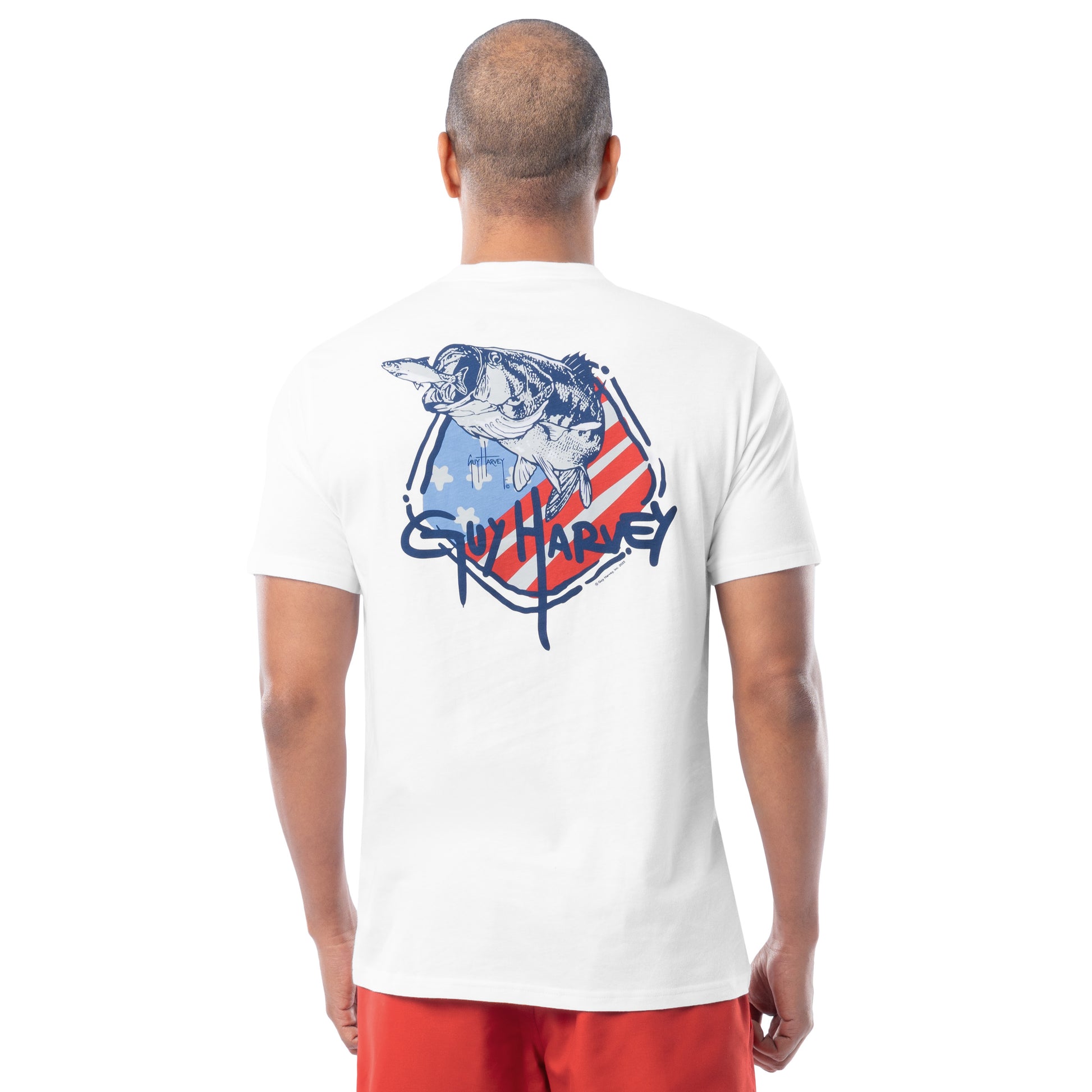 Man wearing a white t-shirt with Guy Harvey bass design in the back, standing against a white background
