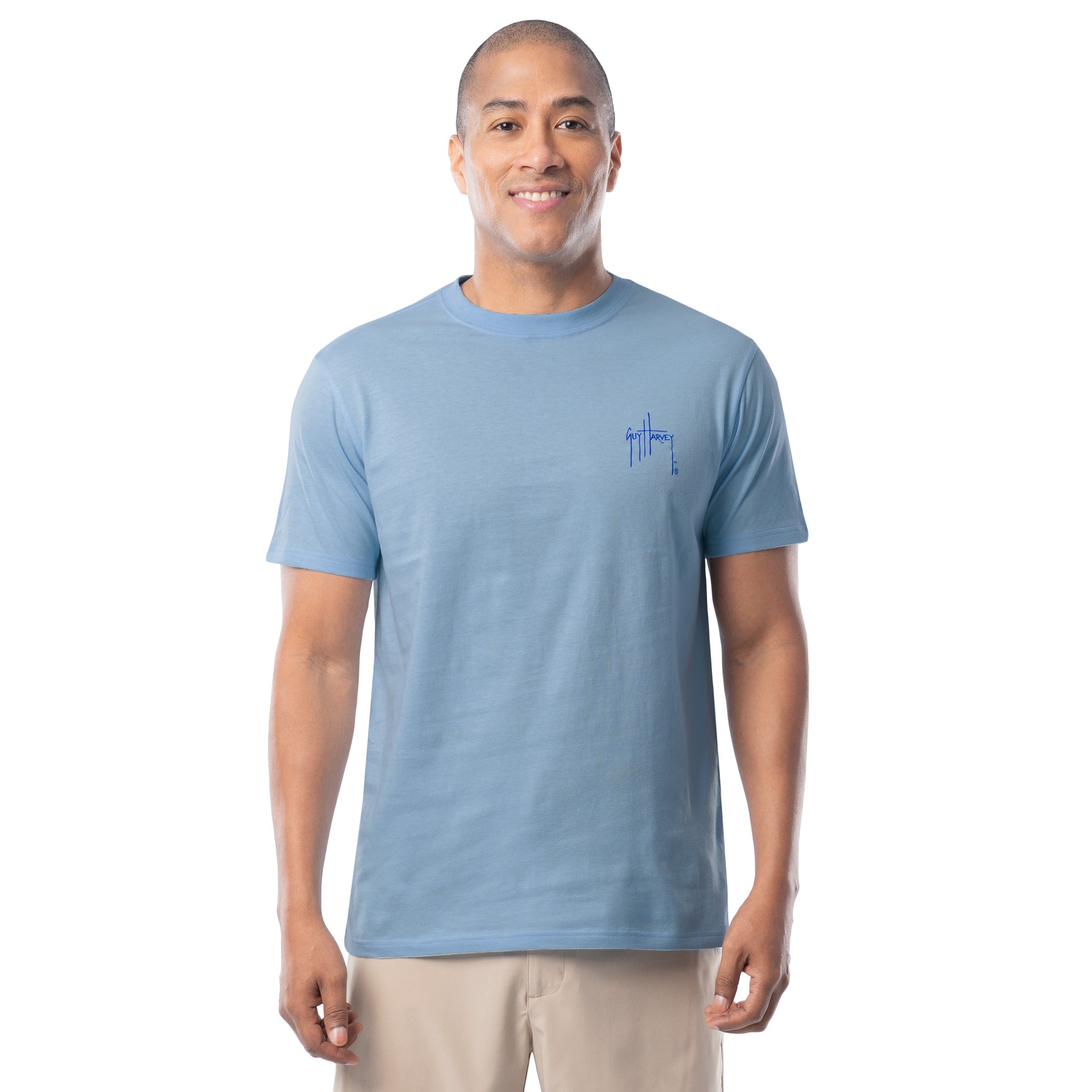 Man wearing a light blue t-shirt with a Guy Harvey logo on a white background