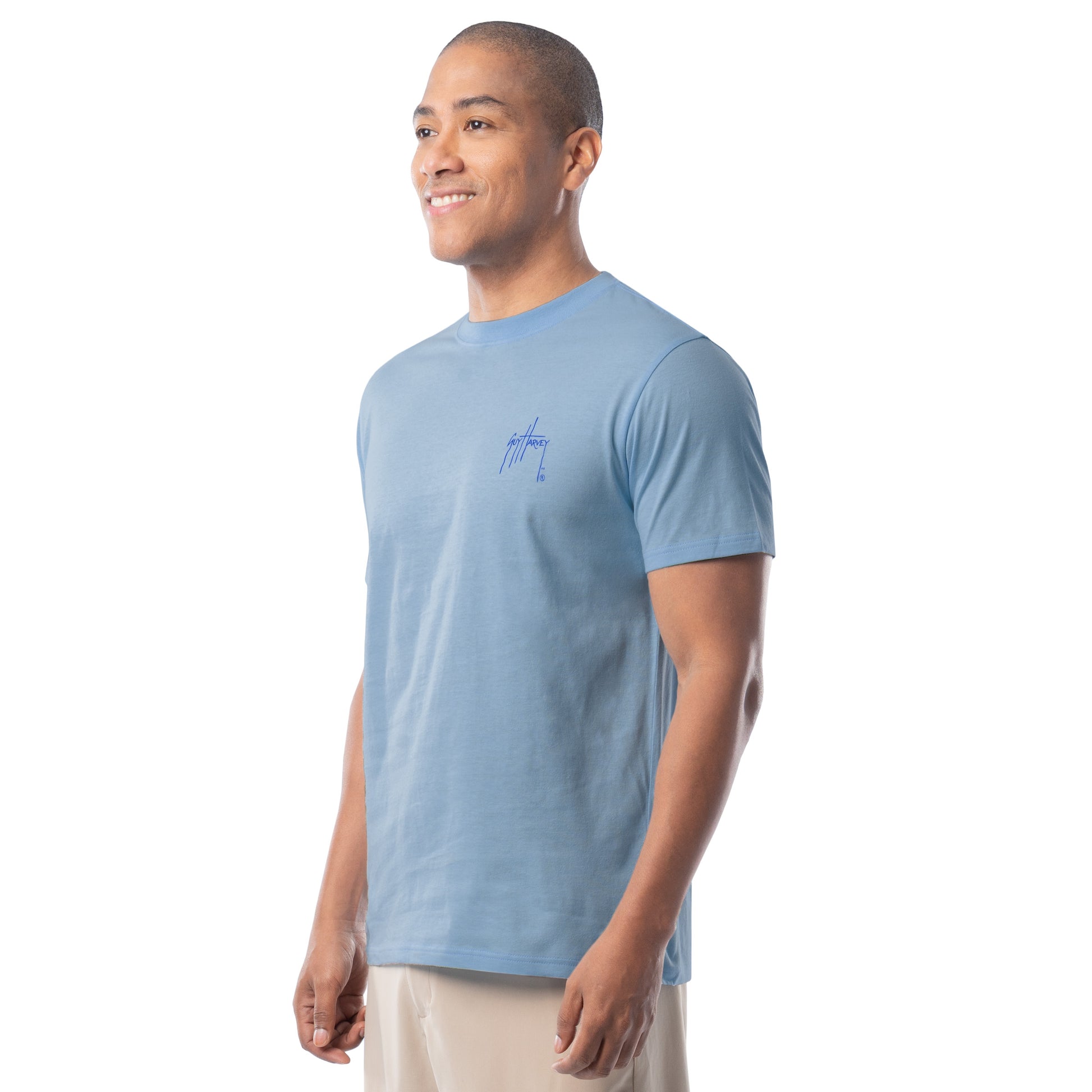 Man wearing a light blue t-shirt with a Guy Harvey logo on a white background
