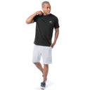 Man wearing a black t-shirt and light gray shorts on a white background