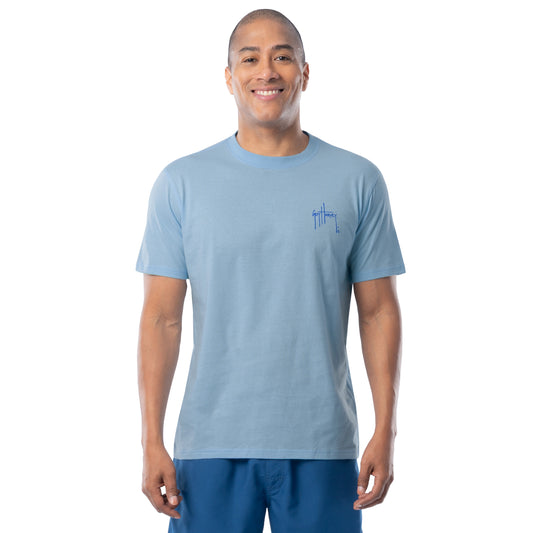 Man wearing a light blue t-shirt with a Guy Harvey logo on a white background