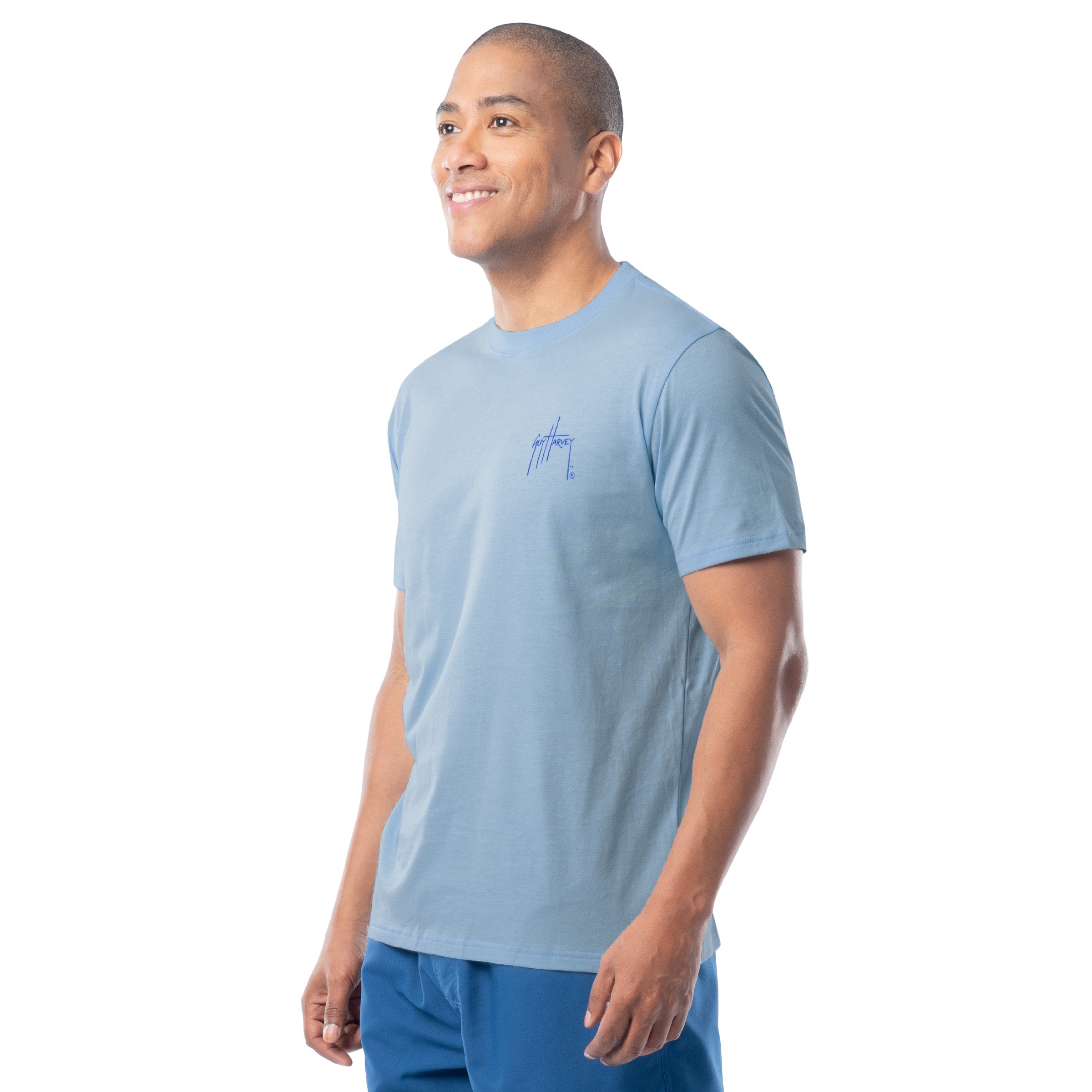 Man wearing a light blue t-shirt with a logo on a white background