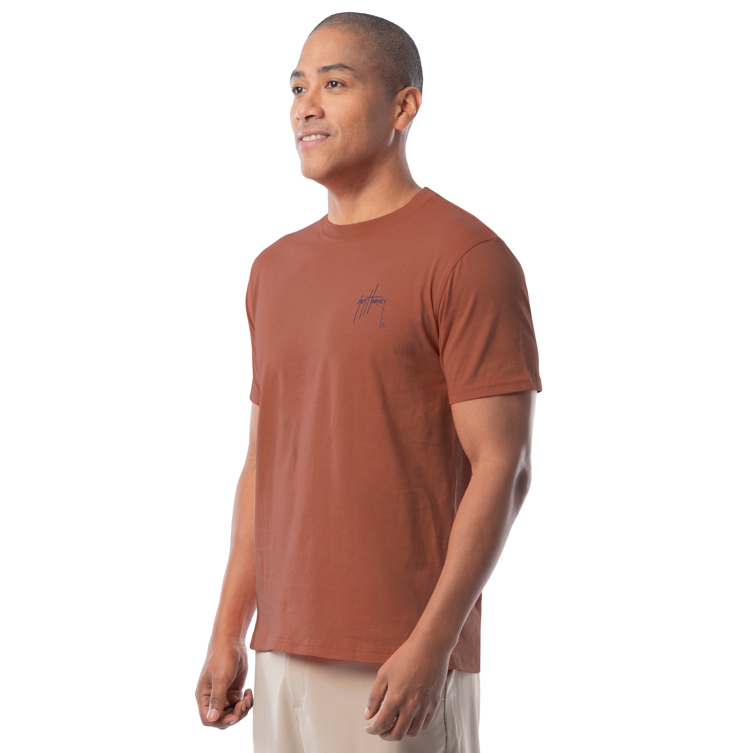 Man wearing a orange t-shirt with a Guy Harvey logo on a white background.