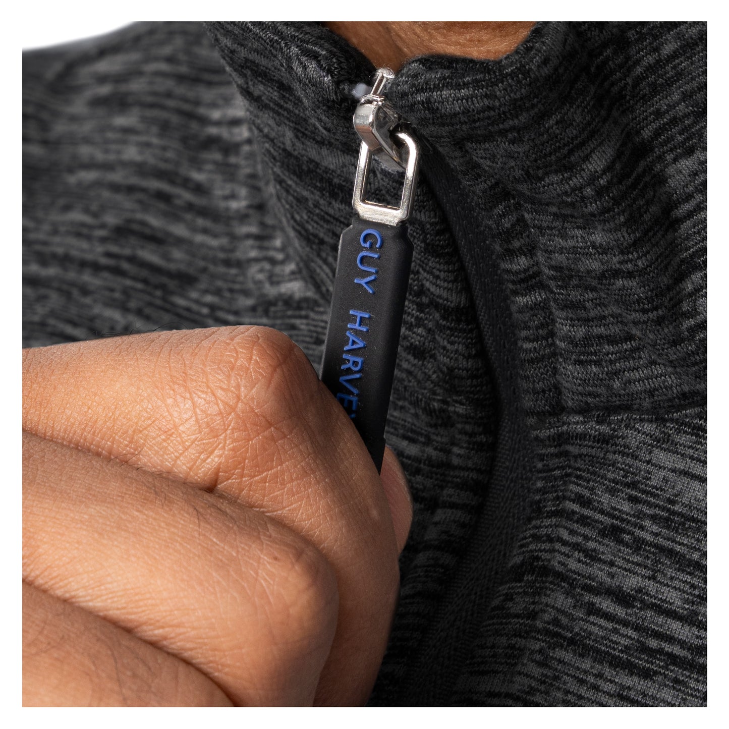 Close-up of Guy Harvey branded zipper pull on black fleece quarter zip pullover