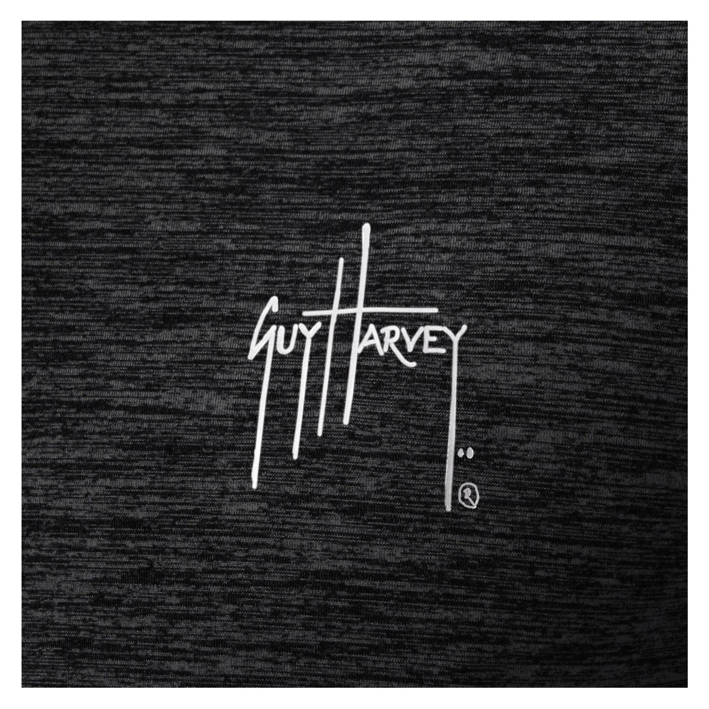 Close-up of white Guy Harvey logo printed on black brushed fleece fabric