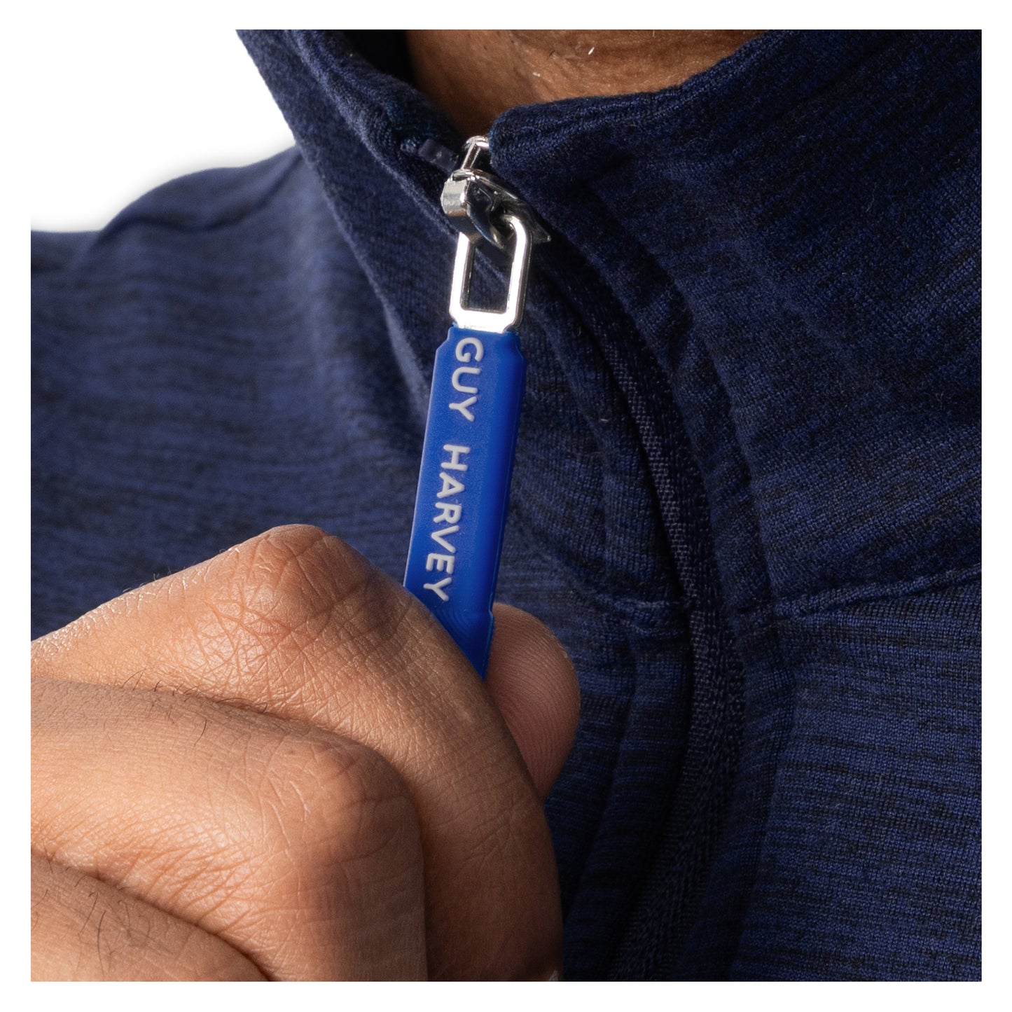 Close-up of Guy Harvey branded blue zipper pull on navy fleece quarter zip pullover
