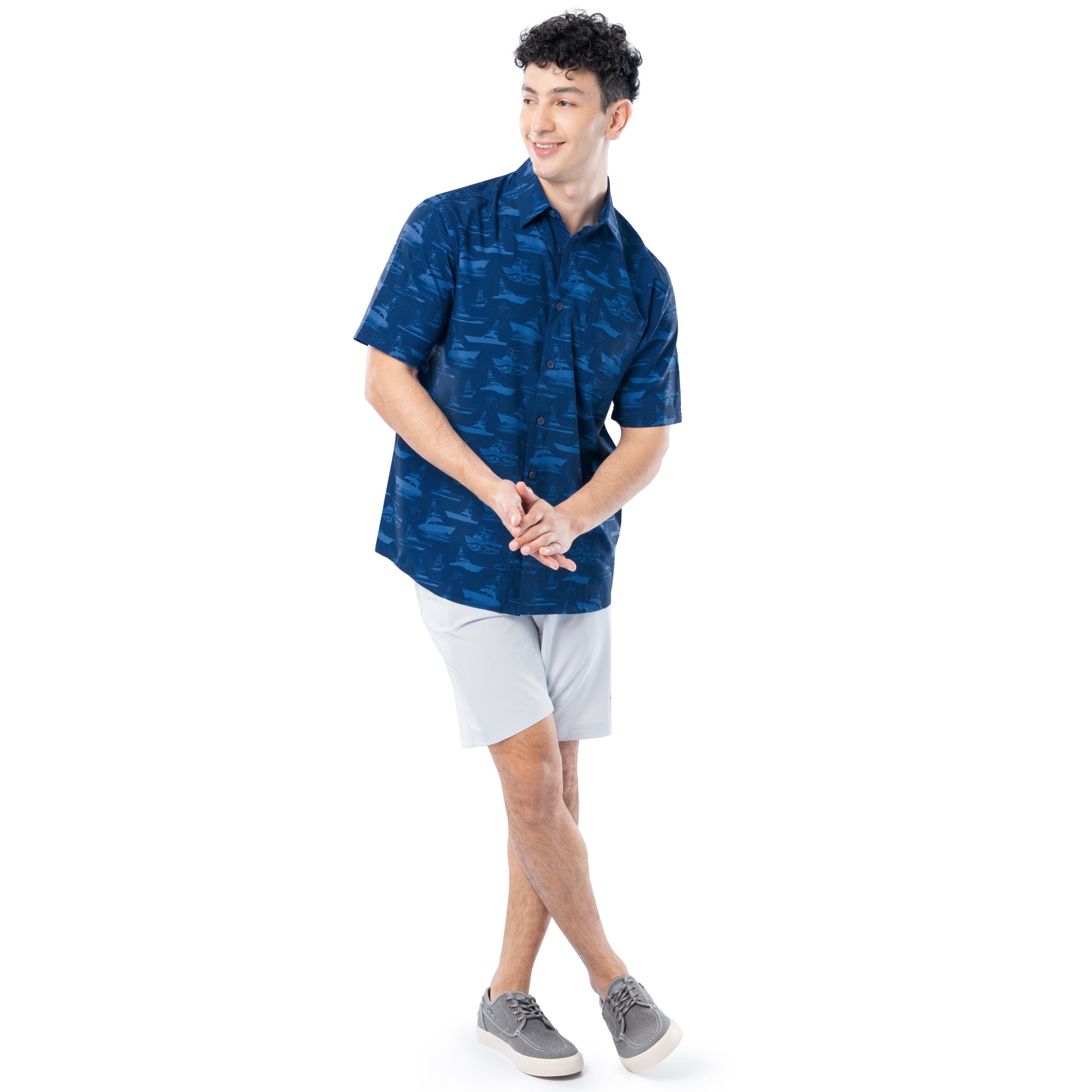 Person wearing a blue patterned shirt and white shorts on a white background