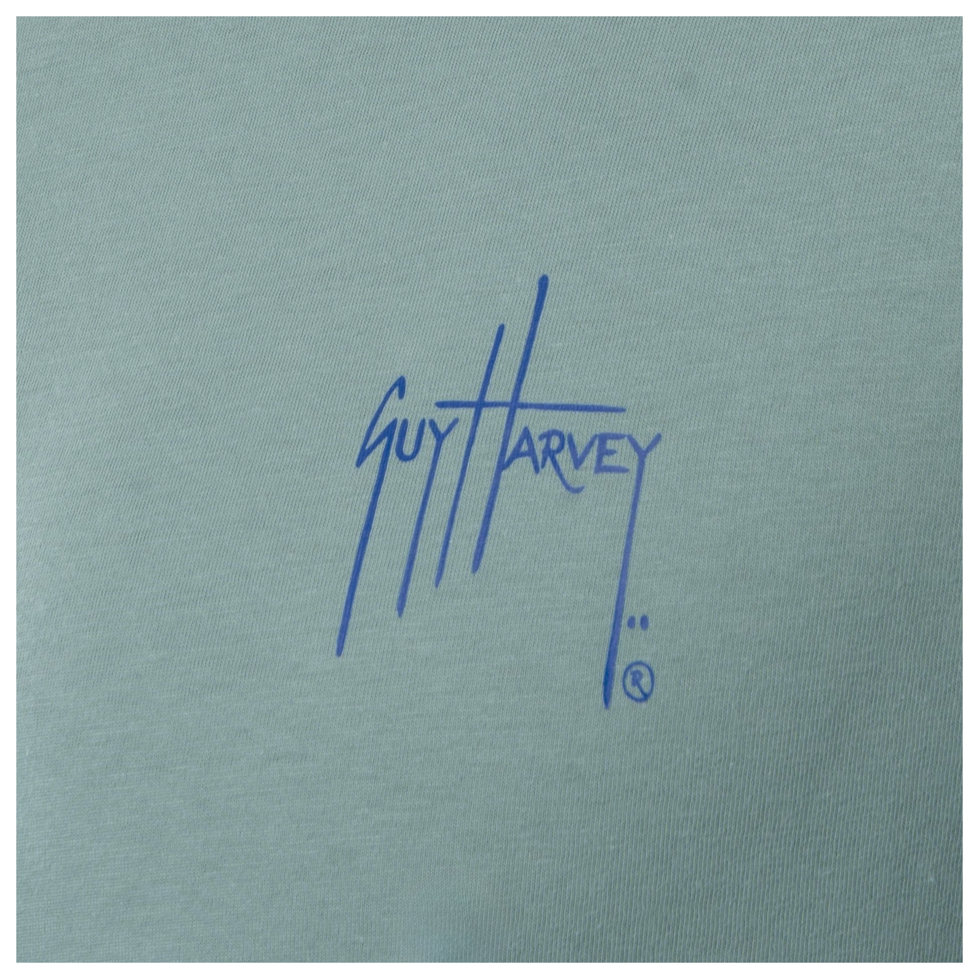 Close-up of blue Guy Harvey chest logo on men’s green freshwater fishing T-shirt