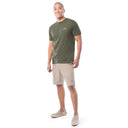 Man wearing a green t-shirt and beige shorts on a white background