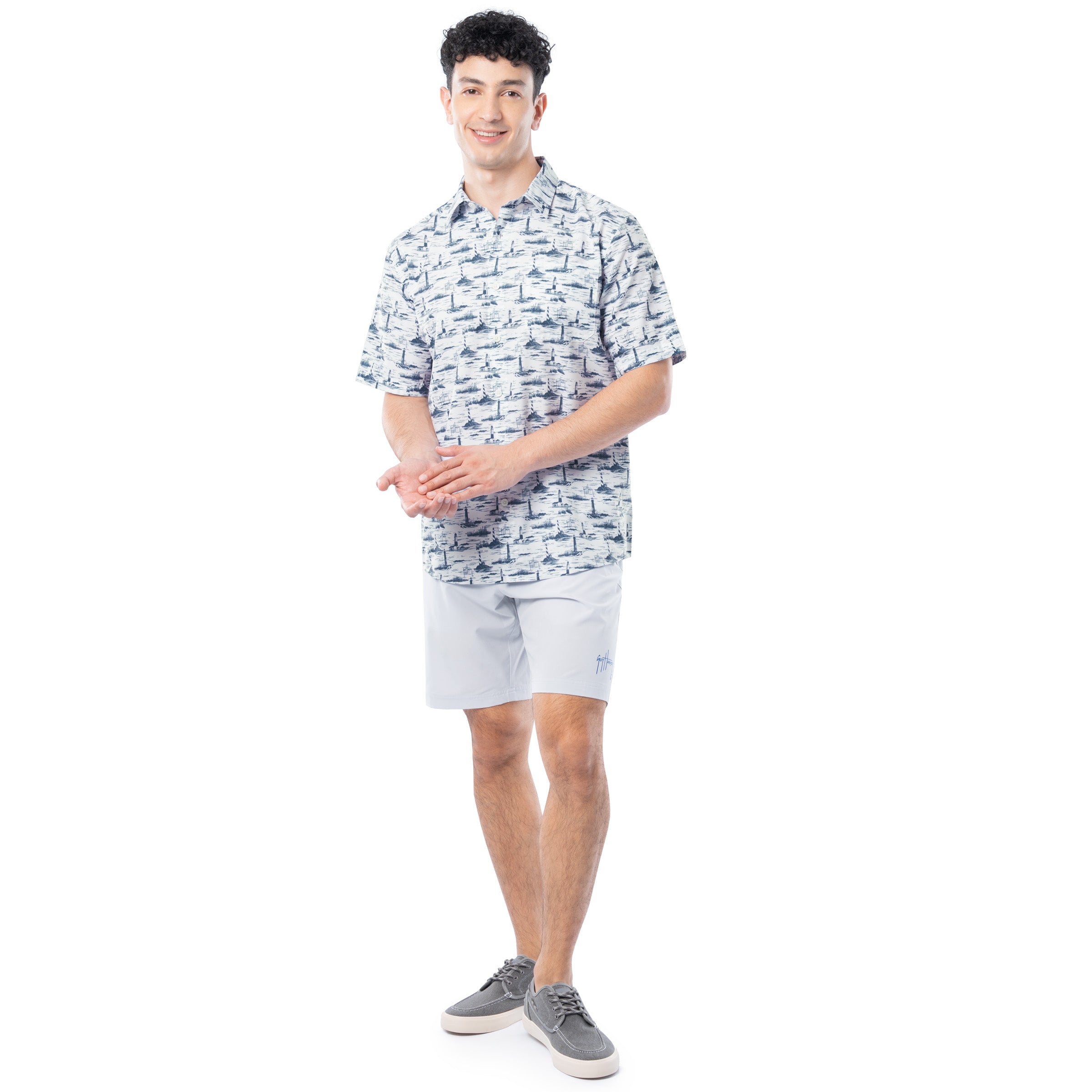 Man wearing a patterned shirt and light shorts on a white background
